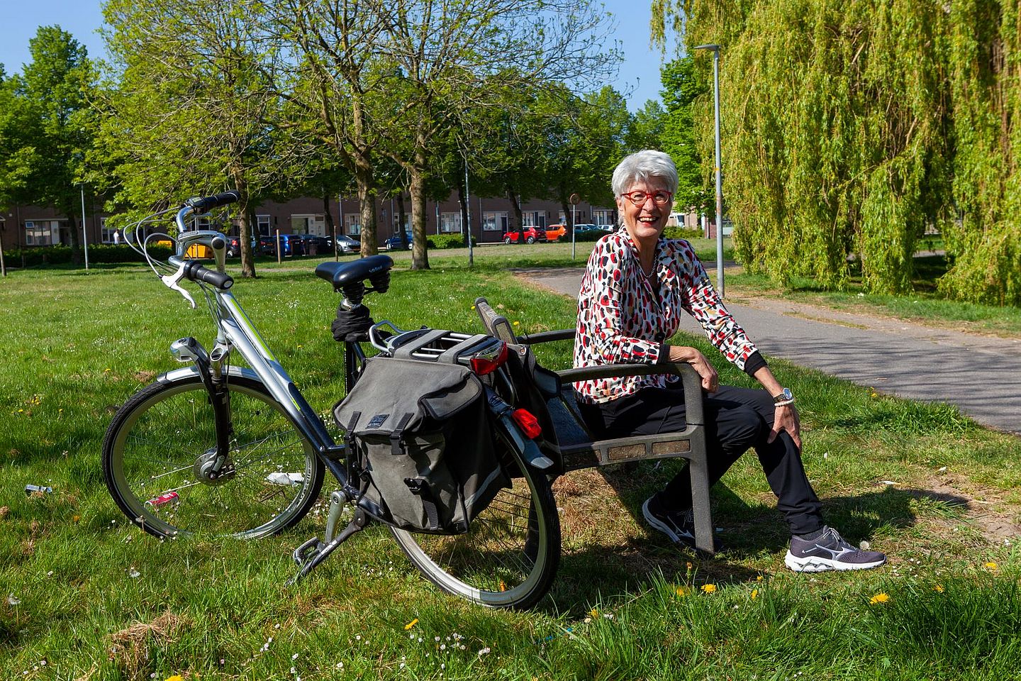 Ada van Gent, consulent mantelzorg bij de VMCA, op een bankje naast haar fiets.